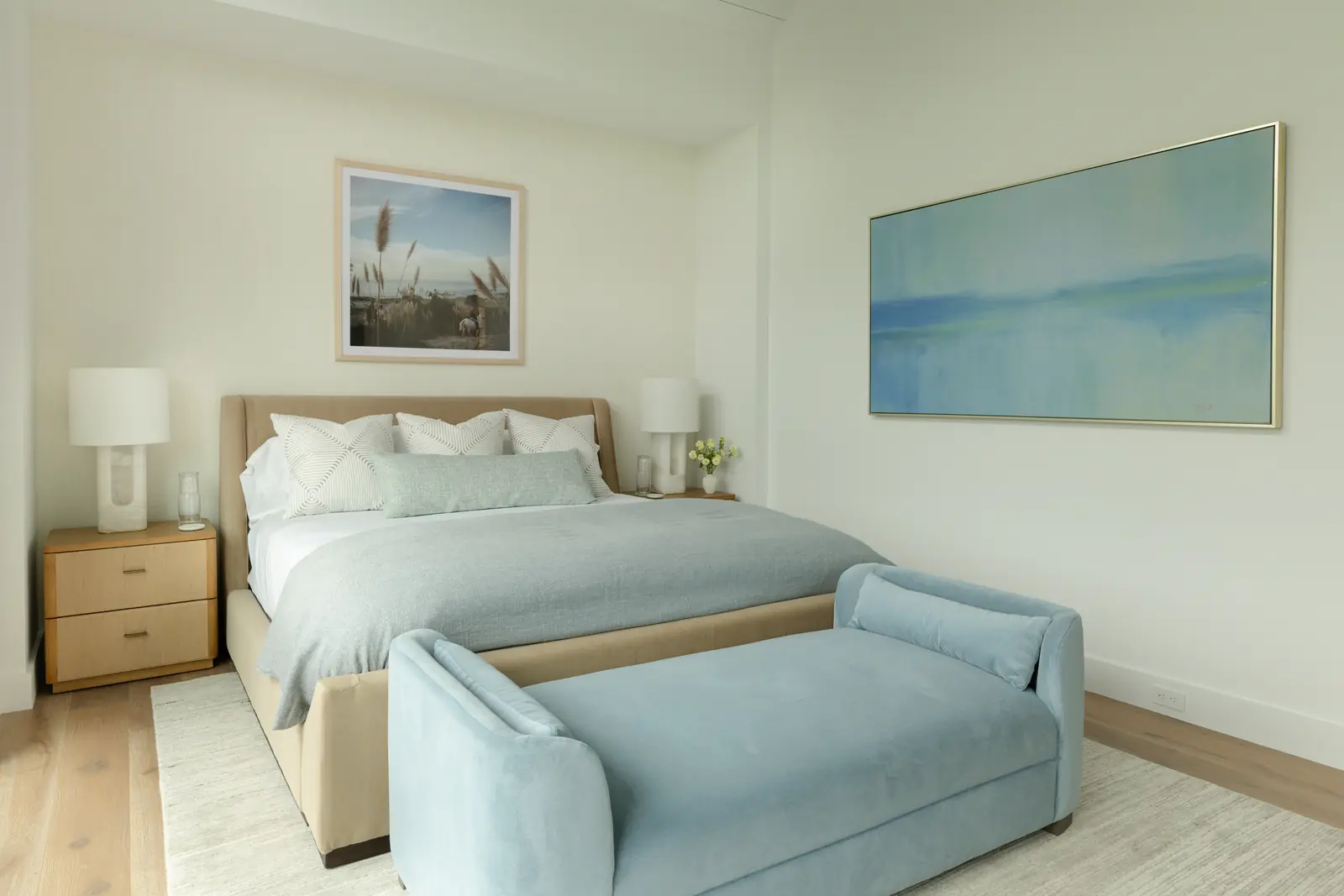 Guest bedroom with a pale blue bench and an ocean painting